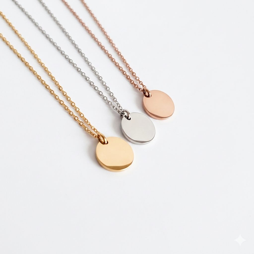 Three gold necklaces with round pendants on a light gray background