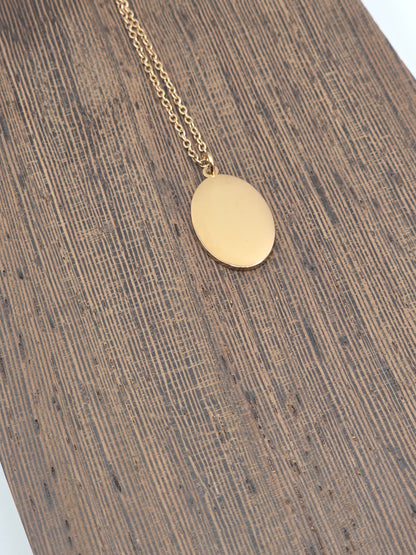 RoseGold necklace with a round pendant on a wooden surface