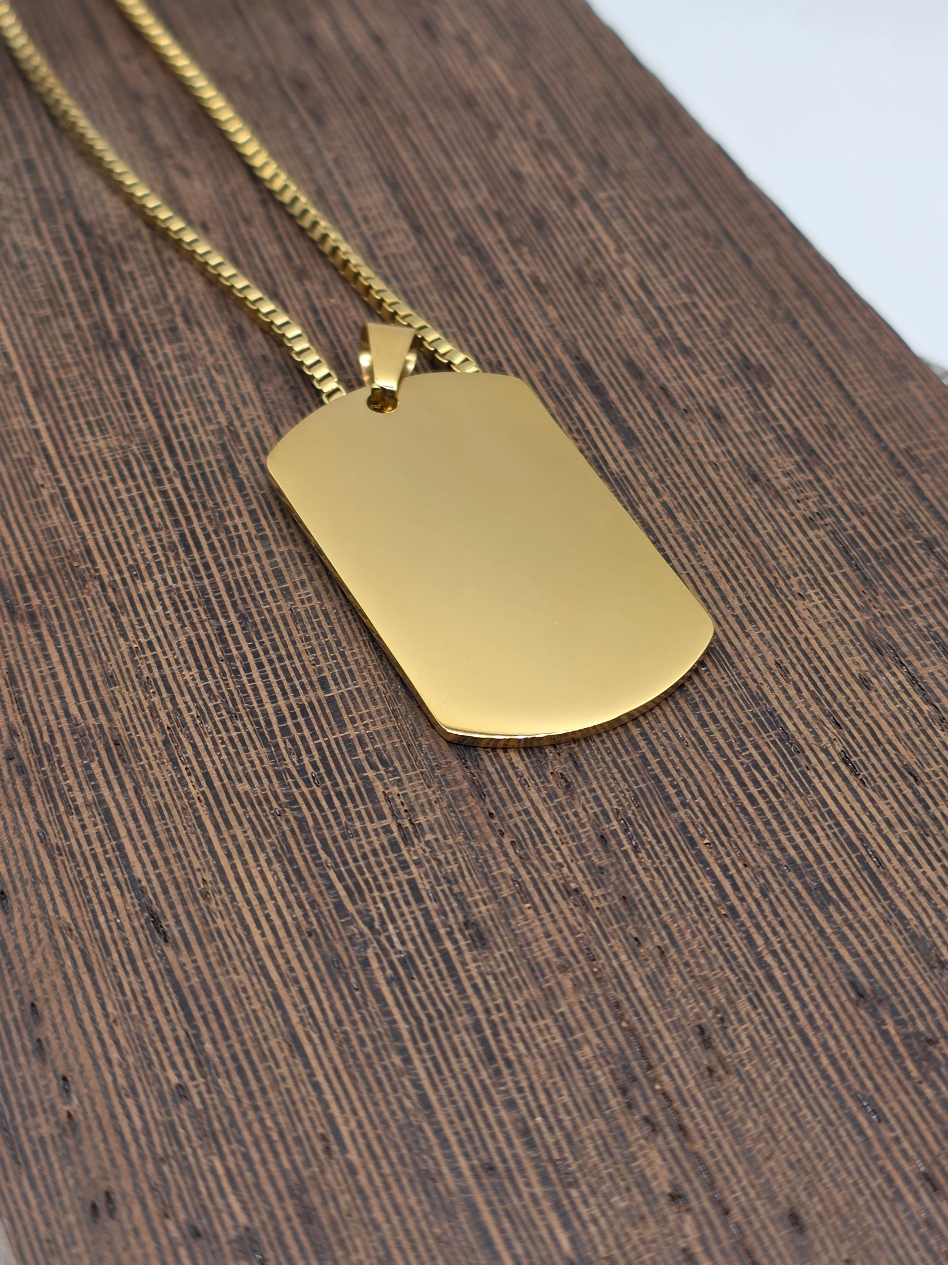 Gold pendant on a chain against a wooden background