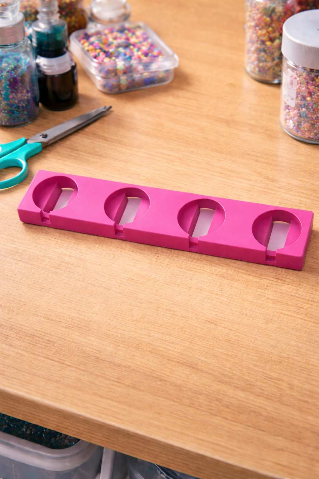Pink tool holder on a wooden table with craft supplies in the background